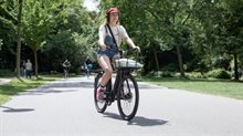 Jonge vrouw op fiets in Vondelpark